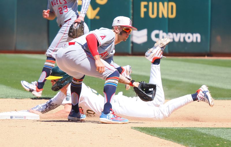 Jul 4, 2024; Oakland, California, USA; Oakland Athletics second baseman Zack Gelof (20) dives safely to second base against Los Angeles Angels shortstop Zach Neto (9) during the sixth inning at Oakland-Alameda County Coliseum. Mandatory Credit: Kelley L Cox-USA TODAY Sports