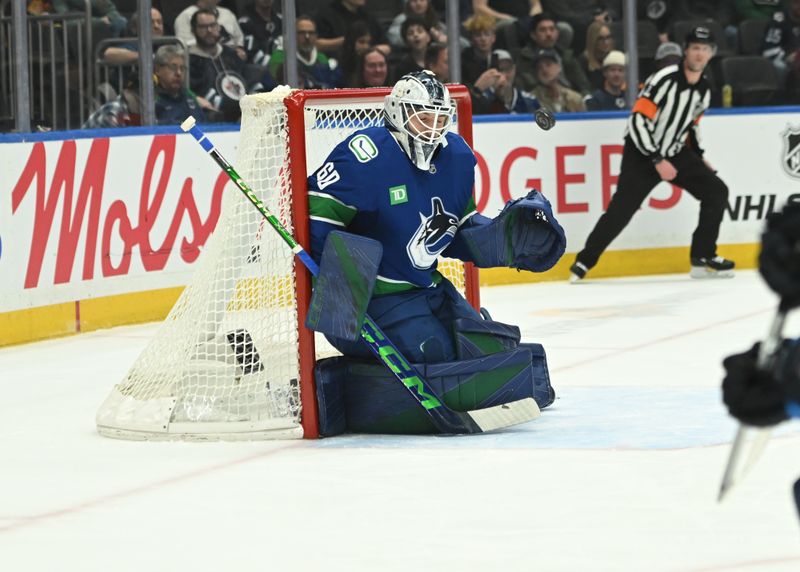 Feb 25, 2026; Vancouver, British Columbia, CAN;Vancouver Canucks goaltender Nikita Tolopilo (60) makes a save against Winnipeg Jets center Mark Scheifele (55) during first period at Rogers Arena. Mandatory Credit: Simon Fearn-Imagn Images
