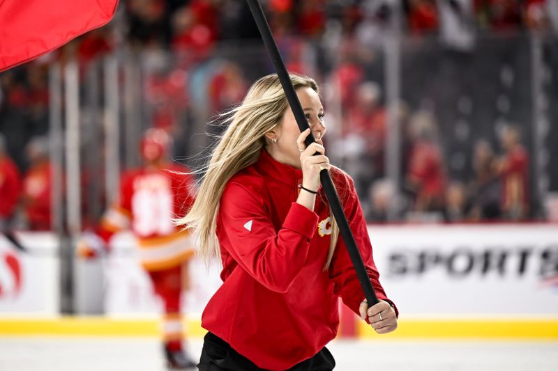 Apr 14, 2024; Calgary, Alberta, CAN; A Calgary Flames ice girl skates with a flag following the Calgary Flames 6-5 win over the Arizona Coyotes at Scotiabank Saddledome. Mandatory Credit: Brett Holmes-USA TODAY Sports