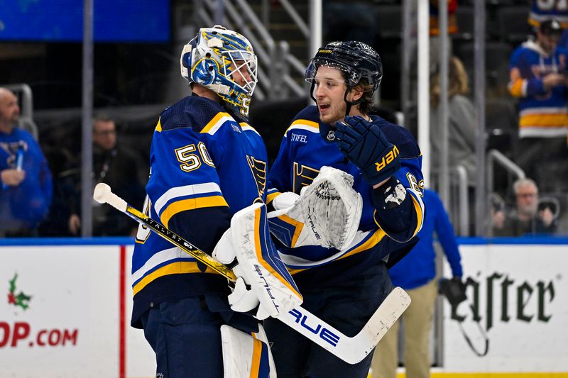 Nov 30, 2023; St. Louis, Missouri, USA;  St. Louis Blues goaltender Jordan Binnington (50) and left wing Jake Neighbours (63) celebrate after the Blues defeated the Buffalo Sabres at Enterprise Center. Mandatory Credit: Jeff Curry-USA TODAY Sports