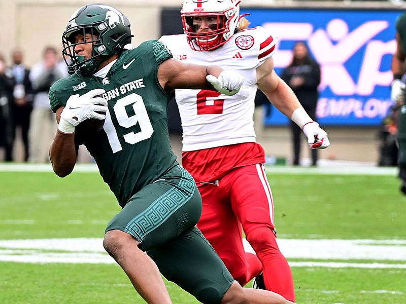 Nov 4, 2023; East Lansing, Michigan, USA;  Michigan State Spartans tight end Jaylan Franklin (19) evades Nebraska Cornhuskers defensive back Isaac Gifford (2) in the first quarter at Spartan Stadium. Mandatory Credit: Dale Young-USA TODAY Sports