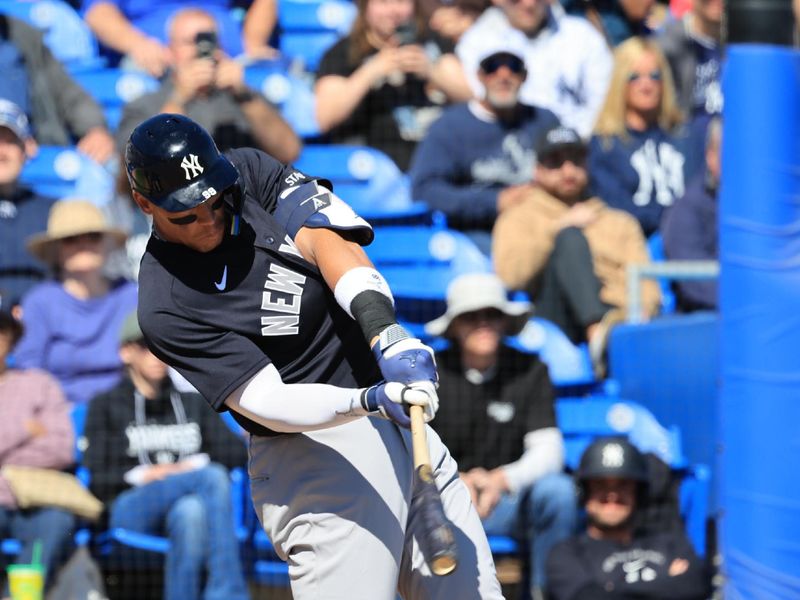 Feb 24, 2026; Dunedin, Florida, USA;  New York Yankees right fielder Aaron Judge (99) singles during the fourth inning against the Toronto Blue Jays at TD Ballpark. Mandatory Credit: Kim Klement Neitzel-Imagn Images