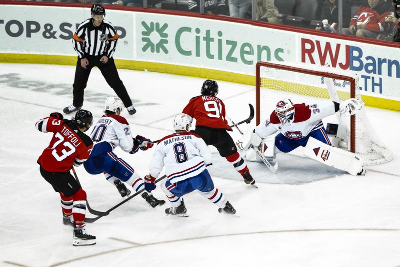 Feb 24, 2024; Newark, New Jersey, USA; Montreal Canadiens goaltender Jake Allen (34) makes a save against New Jersey Devils center Dawson Mercer (91) during the third period at Prudential Center. Mandatory Credit: John Jones-USA TODAY Sports