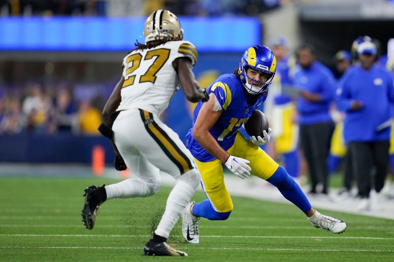 Los Angeles Rams wide receiver Puka Nacua (17) runs after a catch as New Orleans Saints cornerback Isaac Yiadom (27) closes in during the first half of an NFL football game Thursday, Dec. 21, 2023, in Inglewood, Calif. (AP Photo/Ashley Landis)