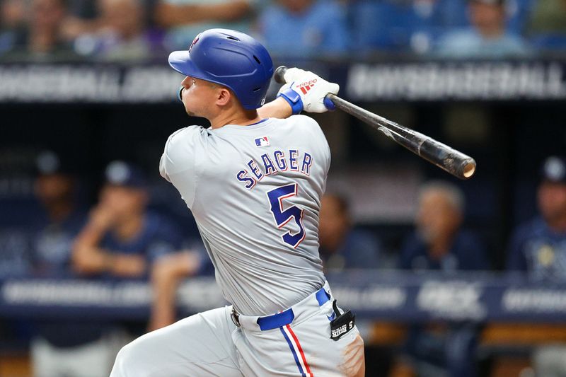 Apr 3, 2024; St. Petersburg, Florida, USA;  Texas Rangers designated hitter Corey Seager (5) hits a solo home run against the Tampa Bay Rays in the sixth inning at Tropicana Field. Mandatory Credit: Nathan Ray Seebeck-USA TODAY Sports