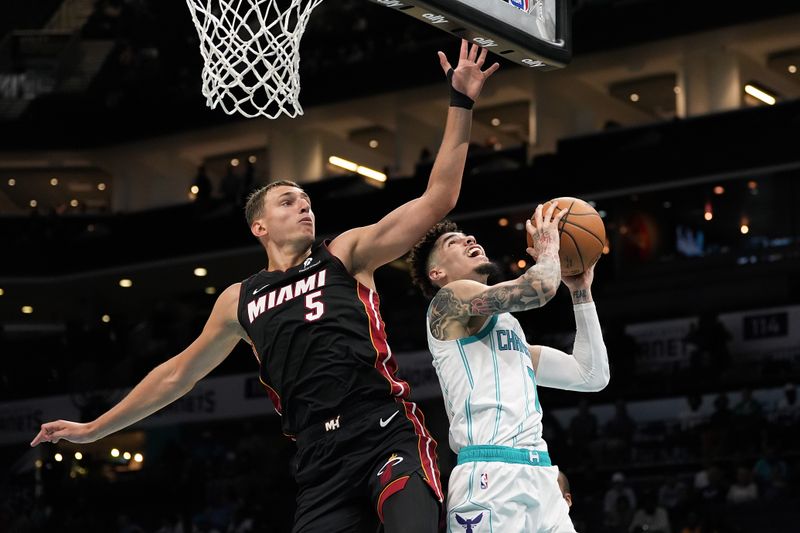 CHARLOTTE, NORTH CAROLINA - OCTOBER 08: Nikola Jovic #5 of the Miami Heat fouls LaMelo Ball #1 of the Charlotte Hornets during the first half of the preseason game at Spectrum Center on October 08, 2024 in Charlotte, North Carolina. NOTE TO USER: User expressly acknowledges and agrees that, by downloading and or using this photograph, User is consenting to the terms and conditions of the Getty Images License Agreement. (Photo by Grant Halverson/Getty Images)