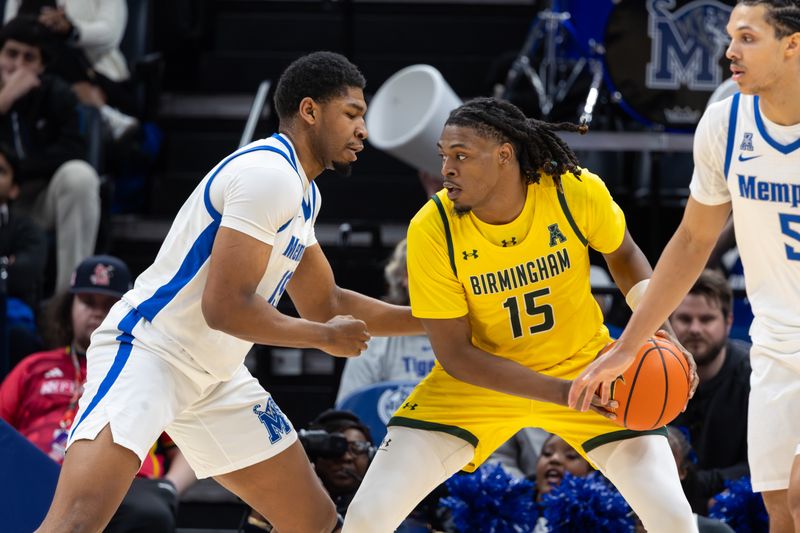 Feb 22, 2026; Memphis, Tennessee, USA; UAB Blazers forward Evan Chatman (15) handles the ball against Memphis Tigers forward Tariq Ingraham (19) during the first half at FedExForum. Mandatory Credit: Wesley Hale-Imagn Images
