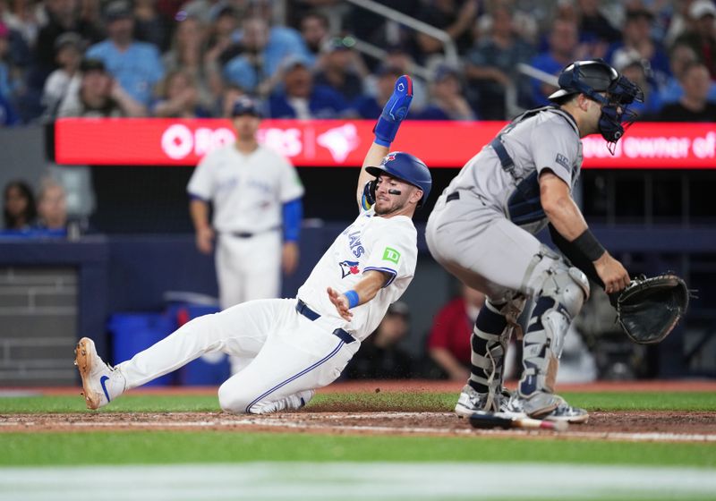 Jun 30, 2024; Toronto, Ontario, CAN; Toronto Blue Jays second baseman Spencer Horwitz (48) slides into home plate scoring a run against the New York Yankees during the third inning at Rogers Centre. Mandatory Credit: Nick Turchiaro-USA TODAY Sports