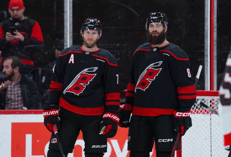 Nov 16, 2024; Raleigh, North Carolina, USA;  Carolina Hurricanes defenseman Jaccob Slavin (74) and  defenseman Brent Burns (8) look on during the third period at Lenovo Center. Mandatory Credit: James Guillory-Imagn Images