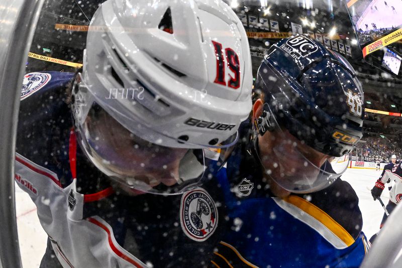 Oct 1, 2024; St. Louis, Missouri, USA; St. Louis Blues defenseman Scott Perunovich (48) checks Columbus Blue Jackets center Adam Fantilli (19) during the first period at Enterprise Center. Mandatory Credit: Jeff Curry-Imagn Images