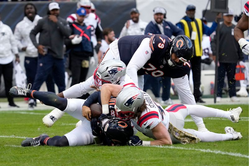 New England Patriots safety Brenden Schooler, right, sacks Chicago Bears quarterback Caleb Williams as linebacker Anfernee Jennings assists during the second half of an NFL football game Sunday, Nov. 10, 2024, in Chicago. (AP Photo/Nam Y. Huh)