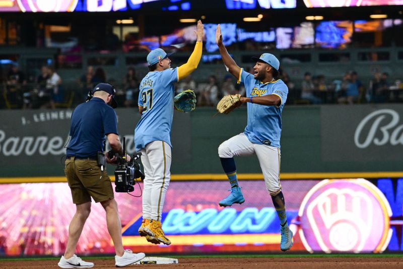 Aug 18, 2024; Milwaukee, Wisconsin, USA; Milwaukee Brewers shortstop Willy Adames (27) and left fielder Jackson Chourio (11) celebrates after beating the Cleveland Guardians at American Family Field. Mandatory Credit: Benny Sieu-USA TODAY Sports