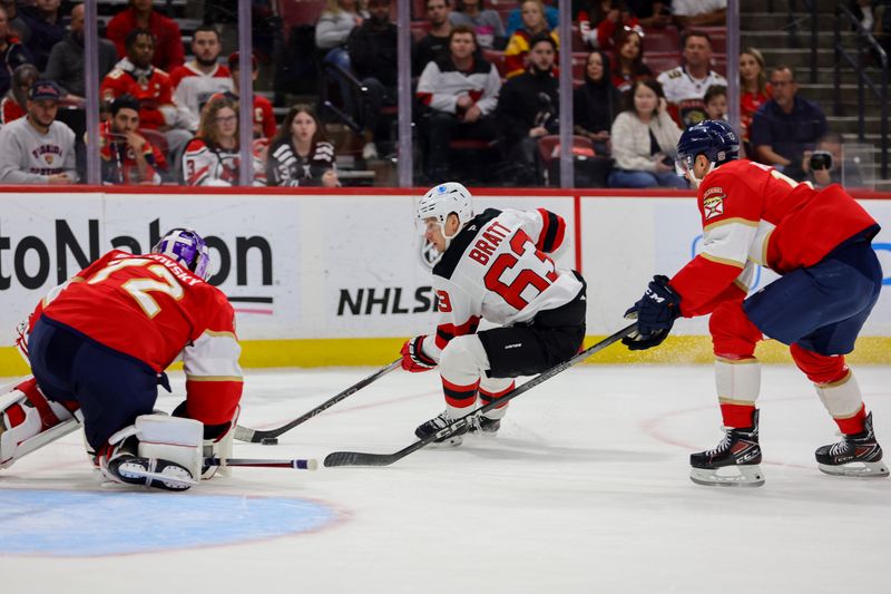 Nov 14, 2024; Sunrise, Florida, USA; New Jersey Devils left wing Jesper Bratt (63) moves the puck ahed of Florida Panthers center Sam Reinhart (13) during the first period at Amerant Bank Arena. Mandatory Credit: Sam Navarro-Imagn Images