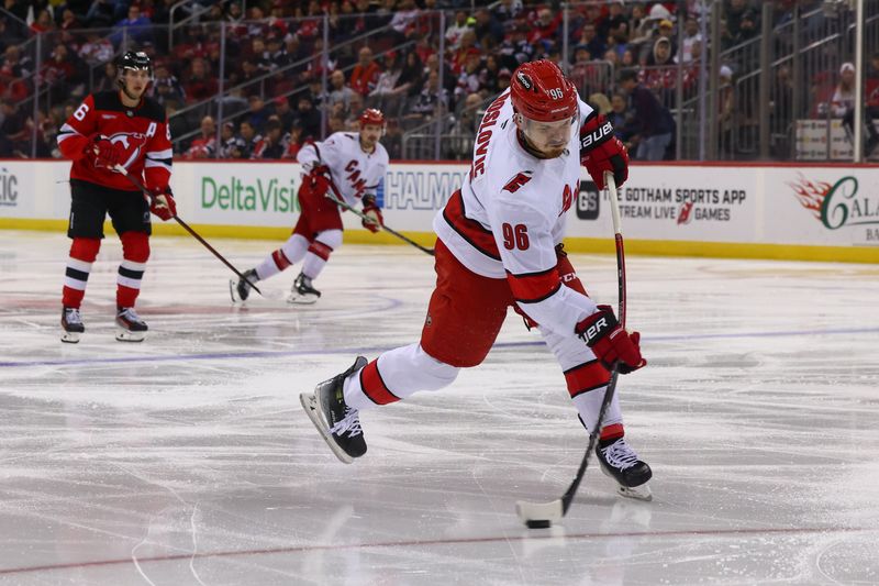 Nov 21, 2024; Newark, New Jersey, USA; Carolina Hurricanes center Jack Roslovic (96) shoots the puck against the New Jersey Devils during the third period at Prudential Center. Mandatory Credit: Ed Mulholland-Imagn Images