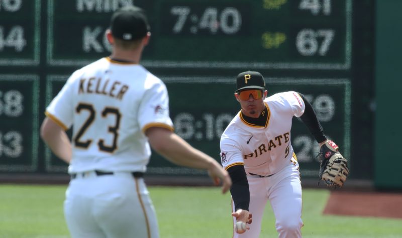 Apr 9, 2025; Pittsburgh, Pennsylvania, USA;  Pittsburgh Pirates first baseman Endy Rodriguez (5) flips the ball to starting pitcher Mitch Keller (23) for an out against the St. Louis Cardinals during the first inning at PNC Park. Mandatory Credit: Charles LeClaire-Imagn Images