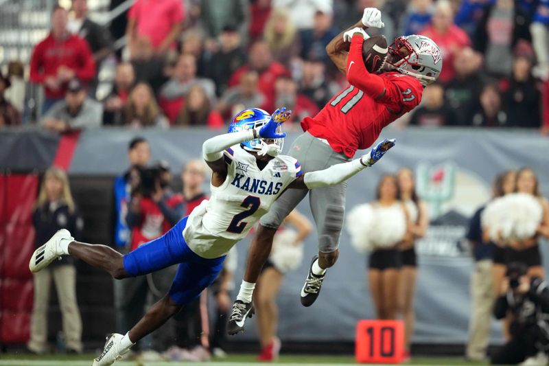 Dec 26, 2023; Phoenix, AZ, USA; UNLV Rebels wide receiver Ricky White (11) catches a touchdown pass against Kansas Jayhawks cornerback Cobee Bryant (2) during the second half at Chase Field. Mandatory Credit: Joe Camporeale-USA TODAY Sports