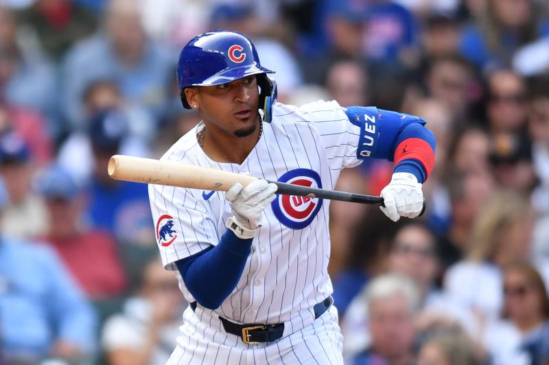 Sep 29, 2024; Chicago, Illinois, USA; Chicago Cubs shortstop Luis Vazquez (12) bunts for his first MLB hit during the seventh inning against the Cincinnati Reds at Wrigley Field. Mandatory Credit: Patrick Gorski-Imagn Images