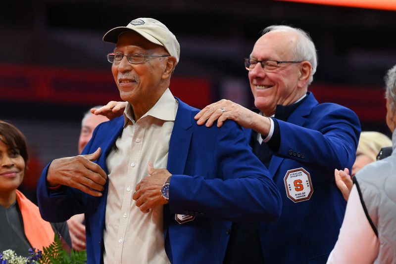 Jan 27, 2024; Syracuse, New York, USA; Former Syracuse Orange head coach Jim Boeheim (right) presents Dave Bing (left) with his Ring of Honor jacket during a ceremony at half time of the game against the North Carolina State Wolfpack at the JMA Wireless Dome. Mandatory Credit: Rich Barnes-USA TODAY Sports