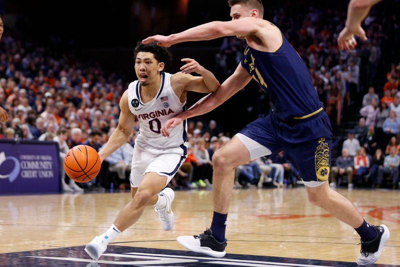 Feb 18, 2023; Charlottesville, Virginia, USA; Virginia Cavaliers guard Kihei Clark (0) controls the ball as Notre Dame Fighting Irish forward Nate Laszewski (14) defends during the second half at John Paul Jones Arena. Mandatory Credit: Amber Searls-USA TODAY Sports