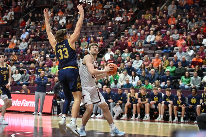 Jan 17, 2026; Blacksburg, Virginia, USA;  Virginia Tech Hokies center Christian Gurdak (32) looks to shoot as Notre Dame Fighting Irish forward Carson Towt (33) defends during the first half at Cassell Coliseum. Mandatory Credit: Brian Bishop-Imagn Images