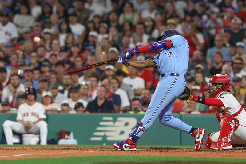 Jun 24, 2024; Boston, Massachusetts, USA; Toronto Blue Jays first baseman Vladimir Guerrero (27) hits a three run home run during the seventh inning against the Boston Red Sox at Fenway Park. Mandatory Credit: Paul Rutherford-USA TODAY Sports