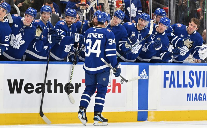 Oct 14, 2023; Toronto, Ontario, CAN;  Toronto Maple Leafs forward Auston Matthews (34) celebrates with teammates at the bench after a goal against the Minnesota Wild in the first period at Scotiabank Arena. Mandatory Credit: Dan Hamilton-USA TODAY Sports