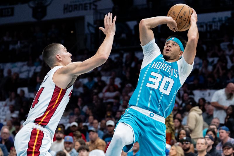 CHARLOTTE, NORTH CAROLINA - OCTOBER 26: Seth Curry #30 of the Charlotte Hornets shoots the ball while guarded by Tyler Herro #14 of the Miami Heat in the first quarter during their game at Spectrum Center on October 26, 2024 in Charlotte, North Carolina. NOTE TO USER: User expressly acknowledges and agrees that, by downloading and or using this photograph, User is consenting to the terms and conditions of the Getty Images License Agreement. (Photo by Jacob Kupferman/Getty Images)