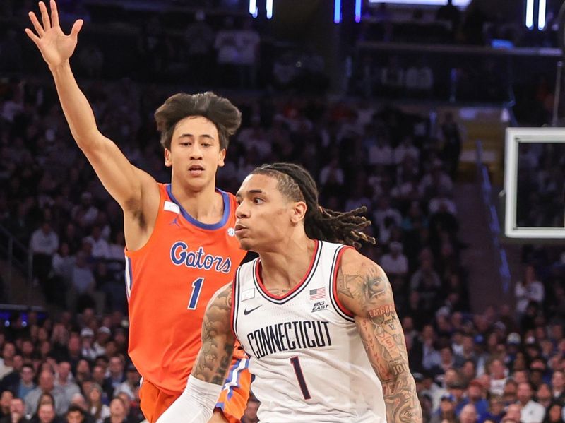 Dec 9, 2025; New York, New York, USA;  UConn Huskies guard Solo Ball (1) drives past Florida Gators guard Xaivian Lee (1) in the first half at Madison Square Garden. Mandatory Credit: Wendell Cruz-Imagn Images