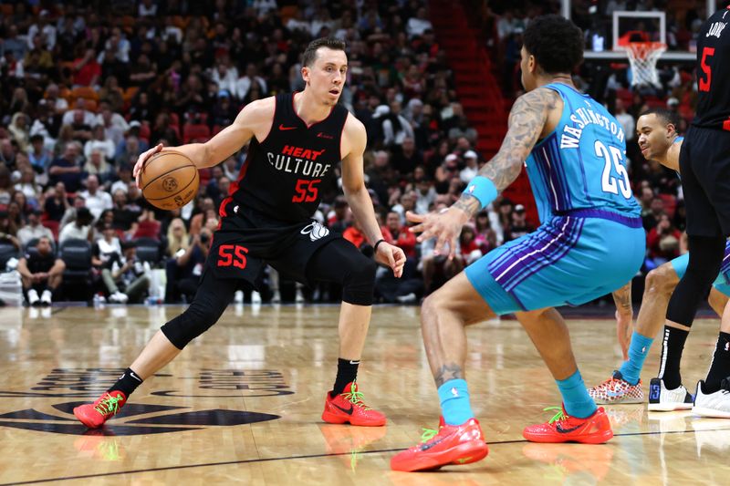 MIAMI, FLORIDA - JANUARY 14: Duncan Robinson #55 of the Miami Heat drives against P.J. Washington #25 of the Charlotte Hornets during the first quarter at Kaseya Center on January 14, 2024 in Miami, Florida. NOTE TO USER: User expressly acknowledges and agrees that, by downloading and or using this photograph, User is consenting to the terms and conditions of the Getty Images License Agreement.  (Photo by Megan Briggs/Getty Images)