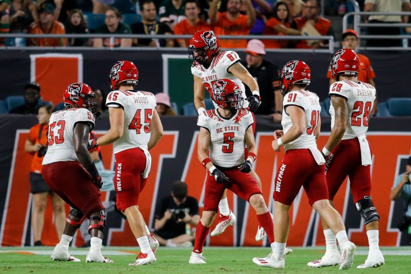 Oct 23, 2021; Miami Gardens, Florida, USA; North Carolina State Wolfpack wide receiver Thayer Thomas (5) celebrates with teammates after scoring a touchdown against the Miami Hurricanes during the second quarter of the game at Hard Rock Stadium. Mandatory Credit: Sam Navarro-USA TODAY Sports