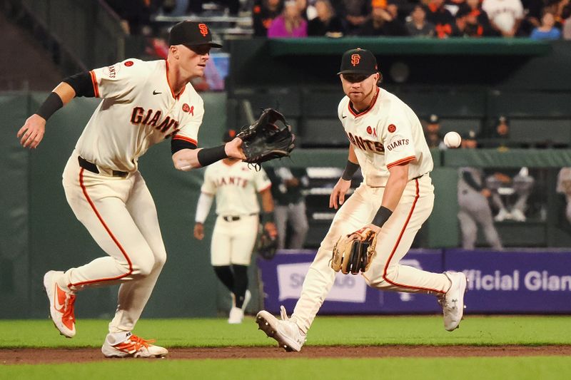 Jul 31, 2024; San Francisco, California, USA; San Francisco Giants shortstop Tyler Fitzgerald (49) gathers the ball with second baseman Brett Wisely (0) during the eighth inning against the Oakland Athletics at Oracle Park. Mandatory Credit: Kelley L Cox-USA TODAY Sports