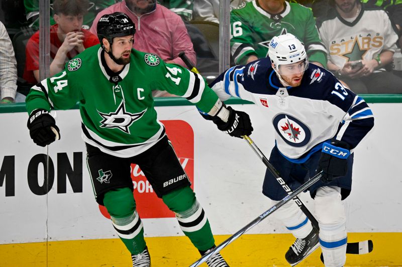 Apr 11, 2024; Dallas, Texas, USA; Dallas Stars left wing Jamie Benn (14) and Winnipeg Jets center Gabriel Vilardi (13) look for the puck during the second period at the American Airlines Center. Mandatory Credit: Jerome Miron-USA TODAY Sports