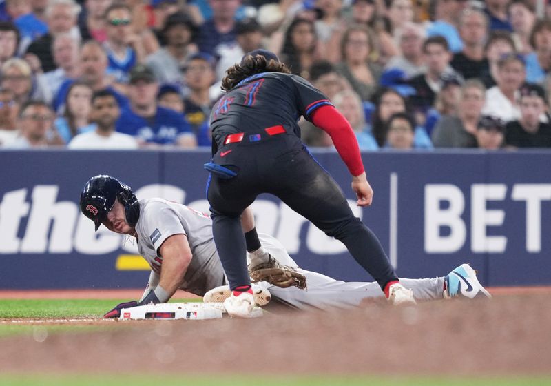 Jun 19, 2024; Toronto, Ontario, CAN; Boston Red Sox center fielder Romy Gonzalez (23) steals third base ahead of the tag from Toronto Blue Jays third baseman Addison Barger (47) during the sixth inning at Rogers Centre. Mandatory Credit: Nick Turchiaro-USA TODAY Sports