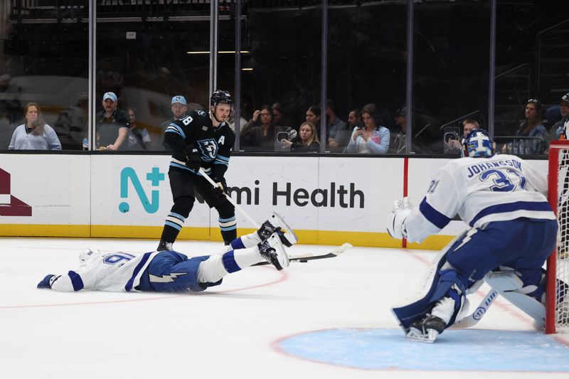 Nov 2, 2025; Salt Lake City, Utah, USA; Tampa Bay Lightning defenseman J.J. Moser (90) slides to cover a potential shot from Utah Mammoth defenseman Mikhail Sergachev (98) during the third period at Delta Center. Mandatory Credit: Rob Gray-Imagn Images
