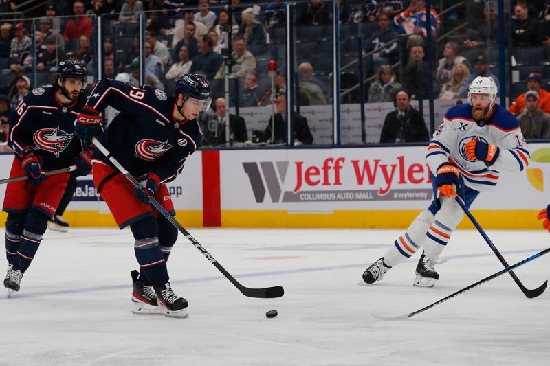 Oct 28, 2024; Columbus, Ohio, USA; Columbus Blue Jackets center Adam Fantilli (19) carries the puck as Edmonton Oilers defenseman Mattias Ekholm (14) defends during the second period at Nationwide Arena. Mandatory Credit: Russell LaBounty-Imagn Images