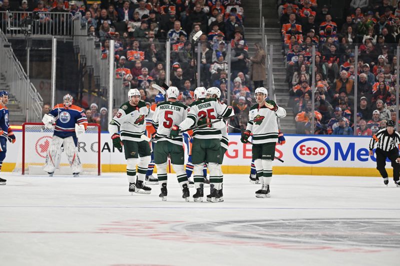 Dec 2, 2025; Edmonton, Alberta, CAN;  Minnesota Wild  center Yakov Trenin (13) with defenseman Jake Middleton  (5) and defenseman Jonas Brodin (25) celebrate a goal on  Edmonton Oilers goalie Stuart Skinner (74) during the first period at Rogers Place. Mandatory Credit: Walter Tychnowicz-Imagn Images