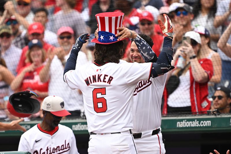 Jul 4, 2024; Washington, District of Columbia, USA; Washington Nationals second baseman Ildemaro Vargas (14) places a patriotic themed top hat on left fielder Jesse Winker (6) after hitting a home run against the New York Mets during the eighth inning at Nationals Park. Mandatory Credit: Rafael Suanes-USA TODAY Sports