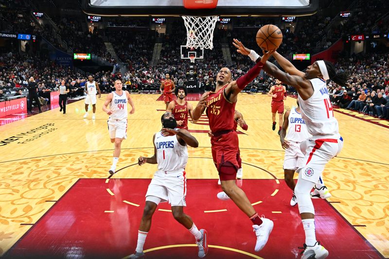 CLEVELAND, OHIO - JANUARY 29: Isaac Okoro #35 of the Cleveland Cavaliers shoots over Terance Mann #14 of the LA Clippers during the third quarter at Rocket Mortgage Fieldhouse on January 29, 2024 in Cleveland, Ohio. The Cavaliers defeated the Clippers 118-108. NOTE TO USER: User expressly acknowledges and agrees that, by downloading and or using this photograph, User is consenting to the terms and conditions of the Getty Images License Agreement. (Photo by Jason Miller/Getty Images)