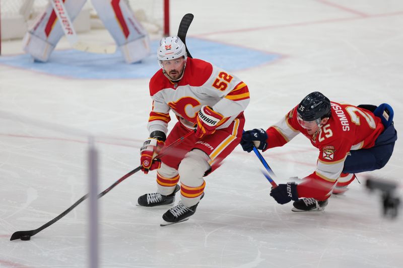 Mar 1, 2025; Sunrise, Florida, USA; Calgary Flames defenseman MacKenzie Weegar (52) moves the puck past Florida Panthers right wing Mackie Samoskevich (25) during the third period at Amerant Bank Arena. Mandatory Credit: Sam Navarro-Imagn Images