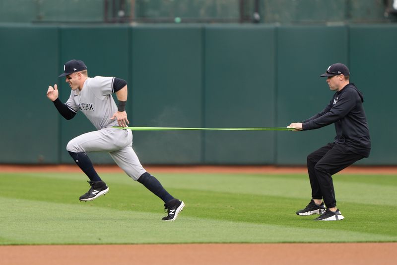 Jun 28, 2023; Oakland, California, USA;  New York Yankees center fielder Harrison Bader (22) works with a trainer during warmups before the start of the first inning against the Oakland Athletics at Oakland-Alameda County Coliseum. Mandatory Credit: Stan Szeto-USA TODAY Sports