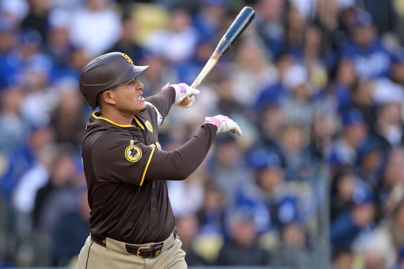 Apr 14, 2024; Los Angeles, California, USA; San Diego Padres third base Manny Machado (13) hits a solo home run in the fourth inning against the Los Angeles Dodgers at Dodger Stadium. Mandatory Credit: Jayne Kamin-Oncea-USA TODAY Sports