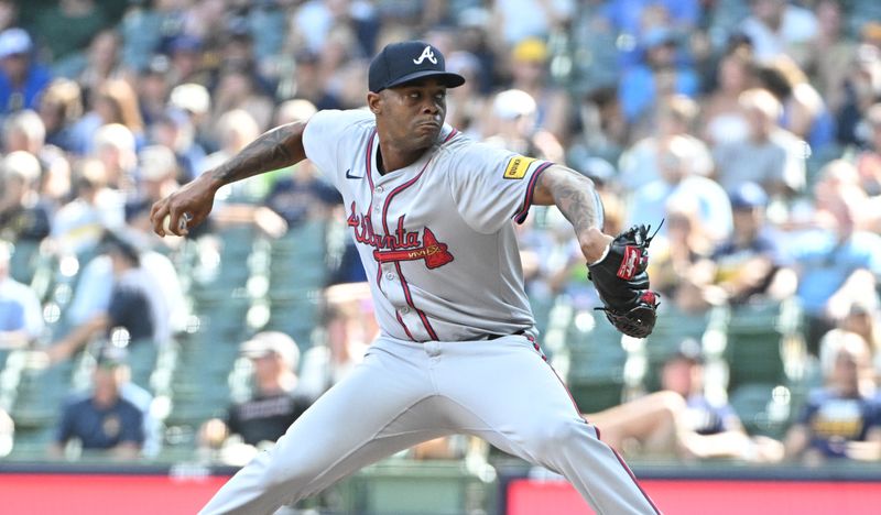 Jul 31, 2024; Milwaukee, Wisconsin, USA; Atlanta Braves pitcher Raisel Iglesias (26) delivers against the Milwaukee Brewers in the ninth inning at American Family Field. Mandatory Credit: Michael McLoone-USA TODAY Sports