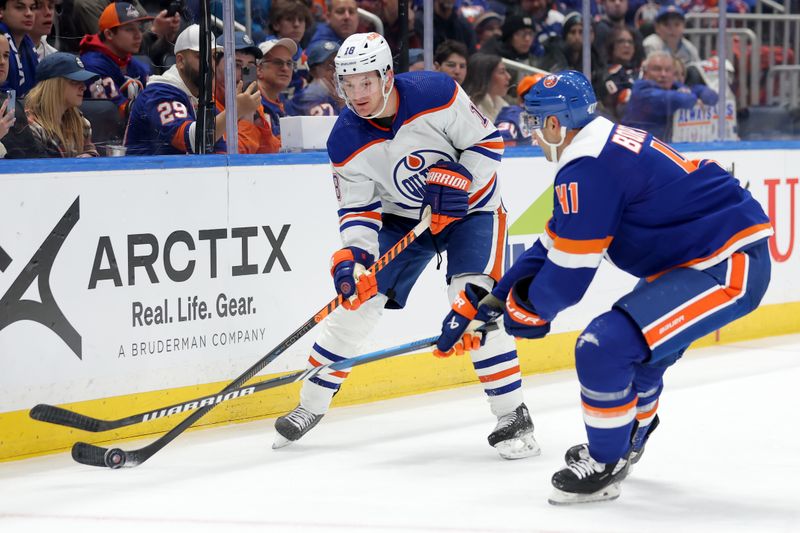 Dec 19, 2023; Elmont, New York, USA; Edmonton Oilers left wing Zach Hyman (18) fights for the puck against New York Islanders defenseman Robert Bortuzzo (41) during the first period at UBS Arena. Mandatory Credit: Brad Penner-USA TODAY Sports