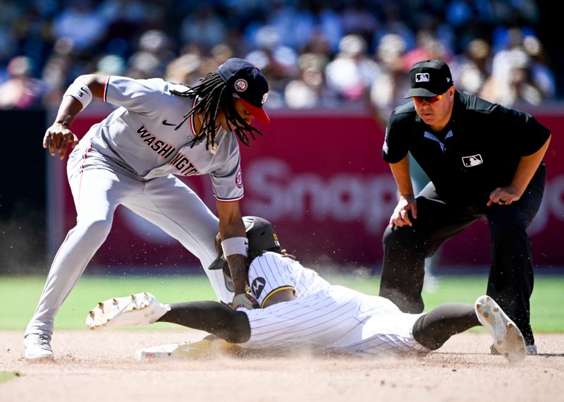 Jun 25, 2025; San Diego, California, USA; San Diego Padres right fielder Fernando Tatis Jr. (23) steals second base ahead of the tag of Washington Nationals shortstop CJ Abrams (5) during the eighth inning at Petco Park. Mandatory Credit: Denis Poroy-Imagn Images