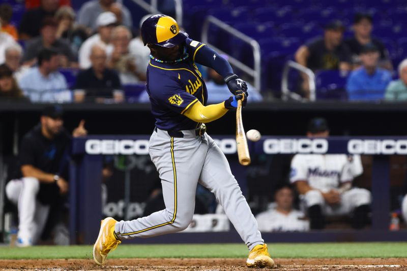 May 20, 2024; Miami, Florida, USA; Milwaukee Brewers second baseman Andruw Monasterio (14) hits a solo home run against the Miami Marlins during the fifth inning at loanDepot Park. Mandatory Credit: Sam Navarro-USA TODAY Sports