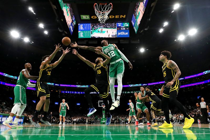 BOSTON, MASSACHUSETTS - MARCH 03: Oshae Brissett #12 of the Boston Celtics reaches for a rebound against Jerome Robinson #18 and Trayce Jackson-Davis #32 of the Golden State Warriors at TD Garden on March 03, 2024 in Boston, Massachusetts. The Celtics defeat the Warriors 140-88. NOTE TO USER: User expressly acknowledges and agrees that, by downloading and or using this photograph, user is consenting to the terms and conditions of the Getty Images License Agreement.  (Photo by Maddie Meyer/Getty Images)