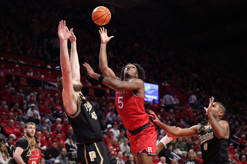 Dec 2, 2025; Piscataway, New Jersey, USA; Rutgers Scarlet Knights guard Darren Buchanan Jr. (5) goes to the basket against Purdue Boilermakers center Oscar Cluff (45) and guard C.J. Cox (0) during the second half at Jersey Mike's Arena. Mandatory Credit: Vincent Carchietta-Imagn Images