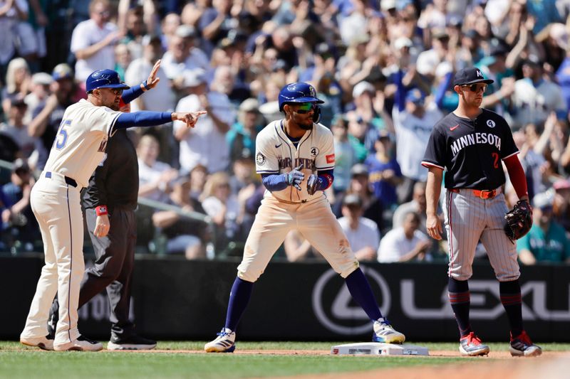 Jun 1, 2025; Seattle, Washington, USA; Seattle Mariners center fielder Julio Rodríguez (44) reacts after advancing to third with Minnesota Twins third baseman Brooks Lee (2) standing to the right during the ninth inning at T-Mobile Park. Mandatory Credit: John Froschauer-Imagn Images