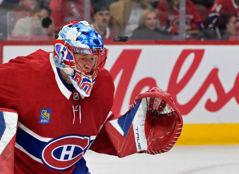 Nov 22, 2025; Montreal, Quebec, CAN; Montreal Canadiens goalie Jakub Dobes (75) stops the puck with his mask during the first period against the Toronto Maple Leafs at the Bell Centre. Mandatory Credit: Eric Bolte-Imagn Images