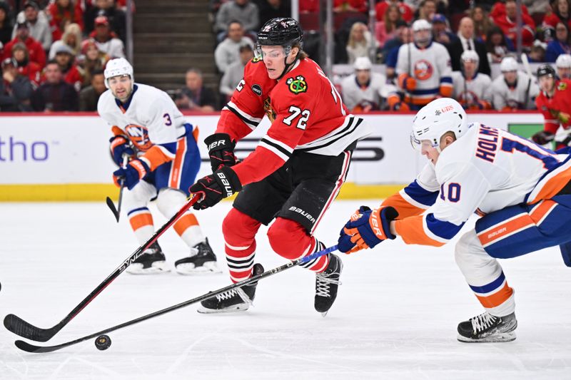 Jan 19, 2024; Chicago, Illinois, USA;  Chicago Blackhawks defenseman Alex Vlasic (72) skates the puck past New York Islanders forward Simon Holmstrom (10) during a power play in the first period at United Center. Mandatory Credit: Jamie Sabau-USA TODAY Sports